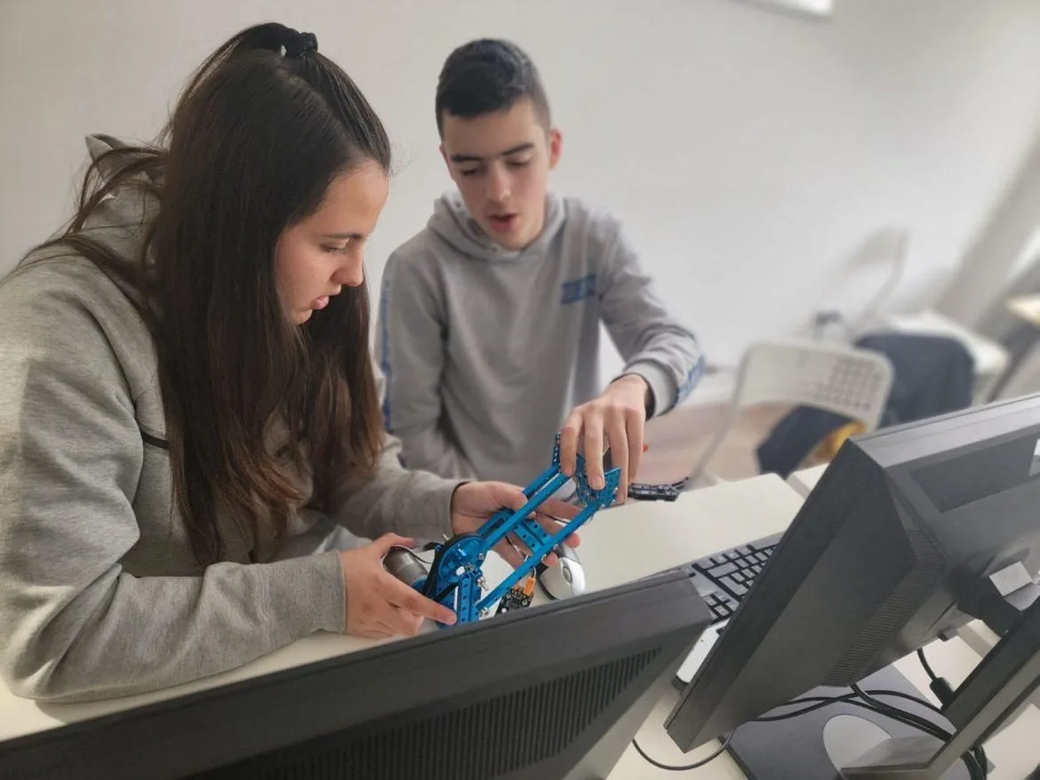 Two children assembling an mBot robot in an IT Clever class